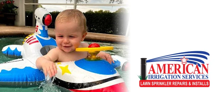 Toddler in an inflatable pool float with the American Irrigation Services logo