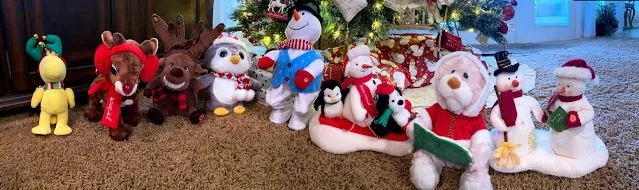Holiday plush toys arranged under a Christmas tree