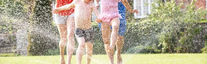 Children playing in a lawn sprinkler